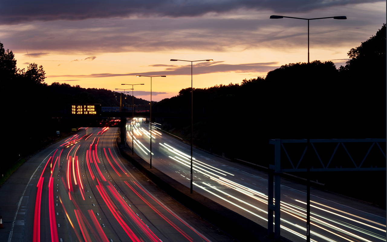 Why-Sourcing-UL-Approved-Cables-from-a-UK-Stockist-Helps-European-Manufacturers-2025-6 UL-approved cables - UK motorway at dusk with light trails showing fast-moving logistics and transport infrastructure– Quadrant Cables